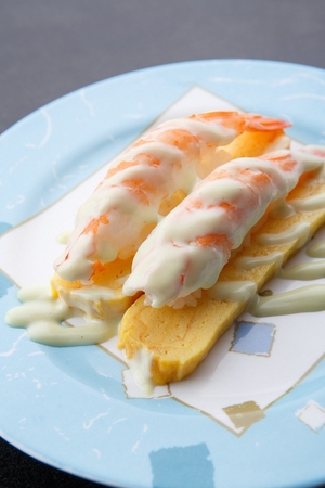 Shrimp sushi on egg with mayonnaise, on a round plateの写真素材