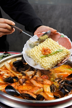 Korean style seafood kimchi stew with various sausages (Haemul Budae jjige), on pot
