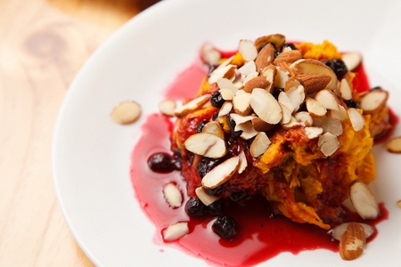 Sweet pumpkin salad with almonds, raisins, strawberry syrup, on white plateの写真素材