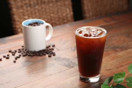 A glass of iced americano on a wooden table