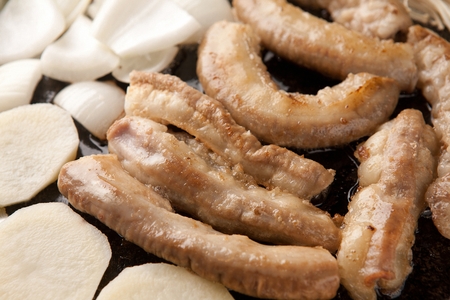 Pork tripes, potatoes, onions, mushrooms on grill. close-upの写真素材