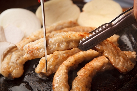 Scissors cutting beef intestines, on black stone tabletの写真素材