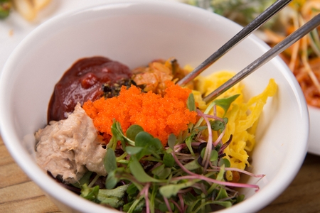 Bibimbap, rice with various vegetables and meat with spicy sauce, on table