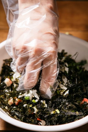 Rice balls with rice, chopped seaweed and crab meat, in white bowlの写真素材