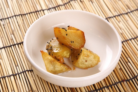 Goguma mat-tang, sweet potatoes cooked in honey, in white plateの写真素材