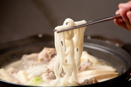 Chopsticks picking up noodles from dak-kalguksu, korean noodle soup dish with cut chicken meat boiled as its brothの写真素材