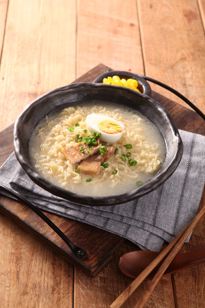 Japanese ramen made of noodles, boiled egg and pork in thick broth, in bowlの写真素材
