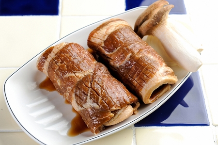 Marinated pork spareribs, onions, king oyster mushrooms on white plate