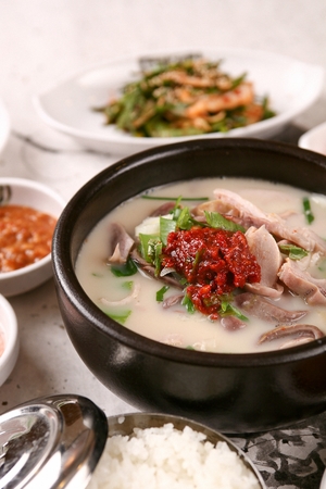 Korean sausages soup, which includes korean sausages and pork intestines, served with rice and chivesの写真素材