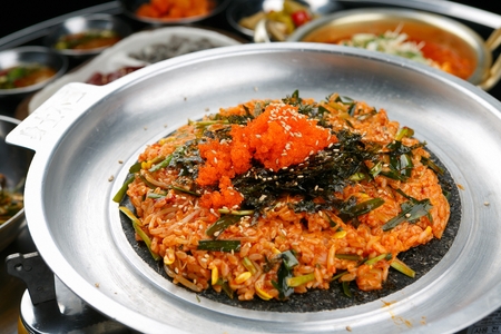 Flying fish roe and seaweed powder sprinkled over bean sprouts and chives stir-fried rice, on black grillの写真素材
