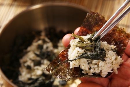 Thistle mixed rice being wrapped in seaweed, in nickel silver plateの写真素材