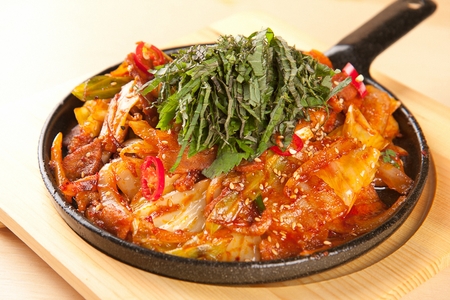 Squid, pork belly and onions stir-fried in spicy sauce, on black oven plateの写真素材