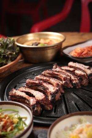 Pork back ribs being grilled on charcoal grillの写真素材