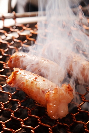 Marinated beef tripes being grilled on charcoal grillの写真素材
