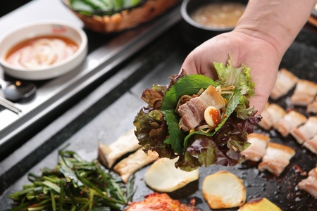 Perilla leaf, bean sprouts, pork belly, garlic and sauce on lettuce