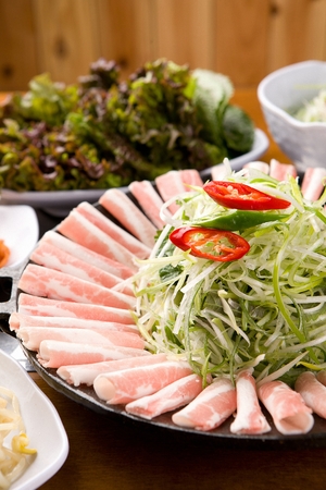 Thin pork belly and seasoned green onions on round plateの写真素材