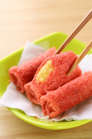 Chopsticks picking up dimsum sweet potato rollの写真素材
