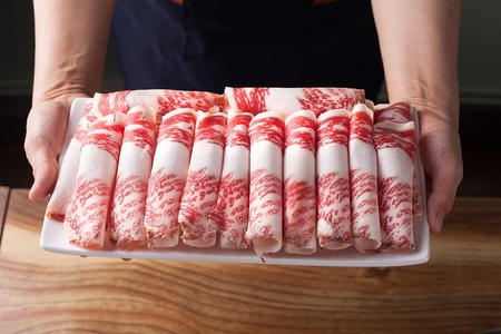 Chef holding a rectangular plate containing beef brisketの写真素材