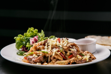 Fajitas - grilled chicken meat and vegetables wrapped in tortillas, on round white plateの写真素材