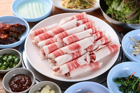 Beef brisket, side dishes and vegetables on round plateの写真素材