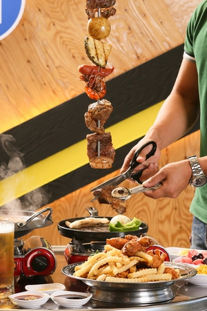 Pork belly from pork belly, shrimp, sausages and pineapple skewer cut into a frying panの写真素材