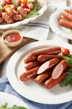 Grilled sausages and chili sauce on round plateの写真素材