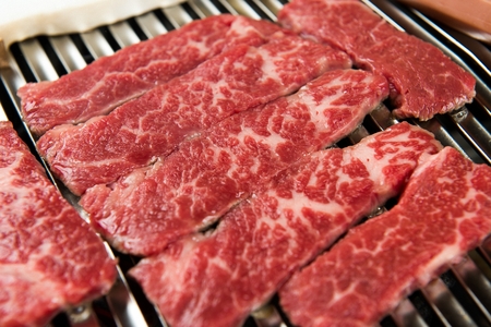 Beef thin flank being grilled on charcoal grill, close-upの写真素材