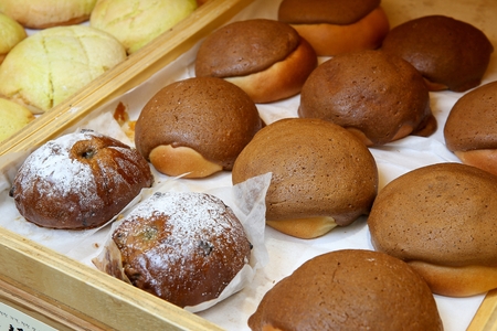 Freshly baked mocha bun and cinnamon bun with lots of raisins, on wooden trey