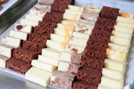 Slice of cheesecake, castella, chocolate brownie on rectangular silver plateの写真素材