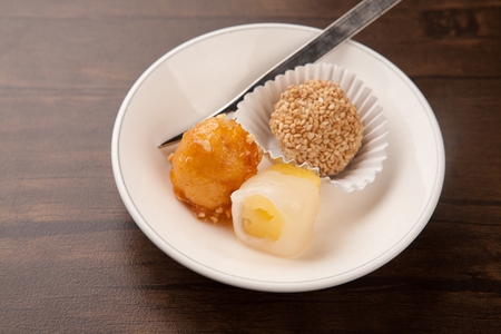 Sweet and sour chicken, wrapped pineapples, bread with sprinkled perilla seeds on round plateの写真素材
