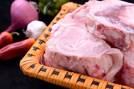 Frozen beef bones in rectangular basketの写真素材