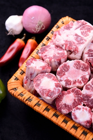 Frozen beef tail in rectangular basket, close-upの写真素材