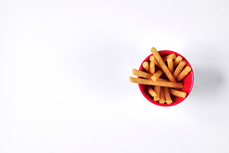 Top view of fried potato stick in red cup on white backgroundの写真素材