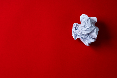 Crumpled paper ball on red backgroundの写真素材
