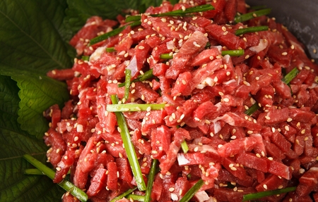 Seasoned beef tartare with chives, on perilla leafの写真素材