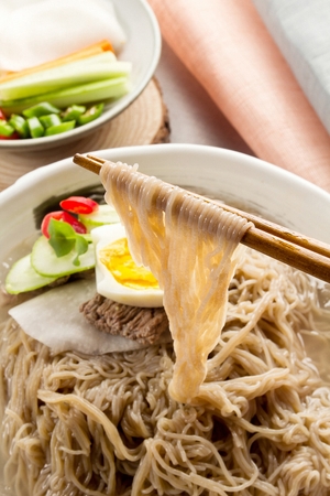 Buckwheat noodles with pear, cucumber and egg, in bowlの写真素材