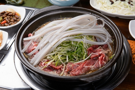 Bulgogi with glass noodles and seasoned green onions, in potの写真素材