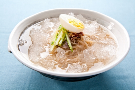 Buckwheat noodles with ice and cucumber, in bowlの写真素材