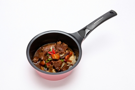 Braised beef short ribs with carrots, oninos and chili, in pot