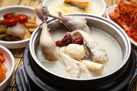 Chicken soup with chestnuts, ginseng, jujube in pot, with side dishesの写真素材