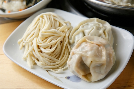 Chopped noodles and dumplings on white rectangular plateの写真素材