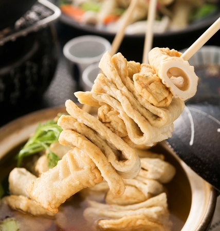 Fish cake skewers with crown daisy, on china plateの写真素材