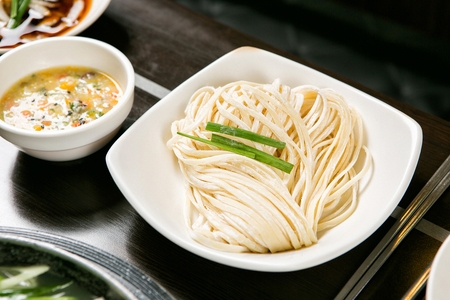 Chopped noodles for duck shabu-shabu on white plate