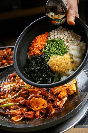 Ingredients for stir-fried rice such as vegetables and small octopus, on iron plateの写真素材