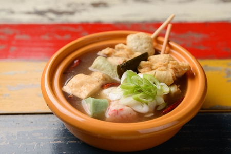 Fish cake skewers soup with walsh onions garnish in china bowl