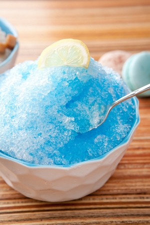 Blue lemon shaved ice with lemon slices, in white bowl