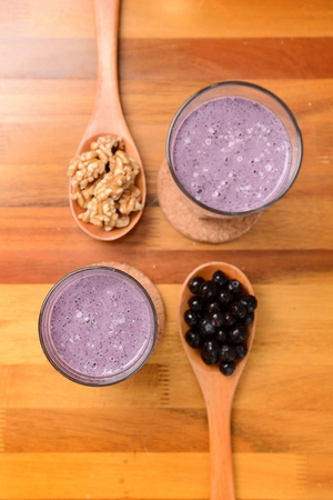 Smoothie made of grinded walnuts and blueberry in glassの写真素材
