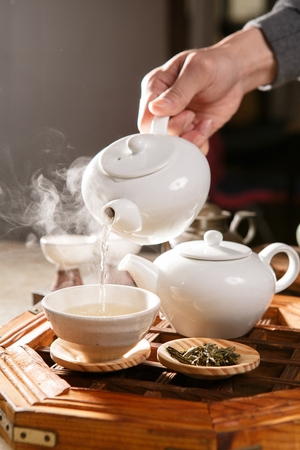 Traditional kettle and teacup containing hot teaの写真素材