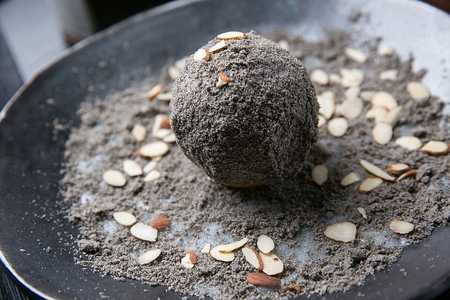 Black sesame rice cakes with almonds on black plate