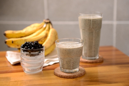 Smoothie made of grinded bananas and black beans in glassの写真素材